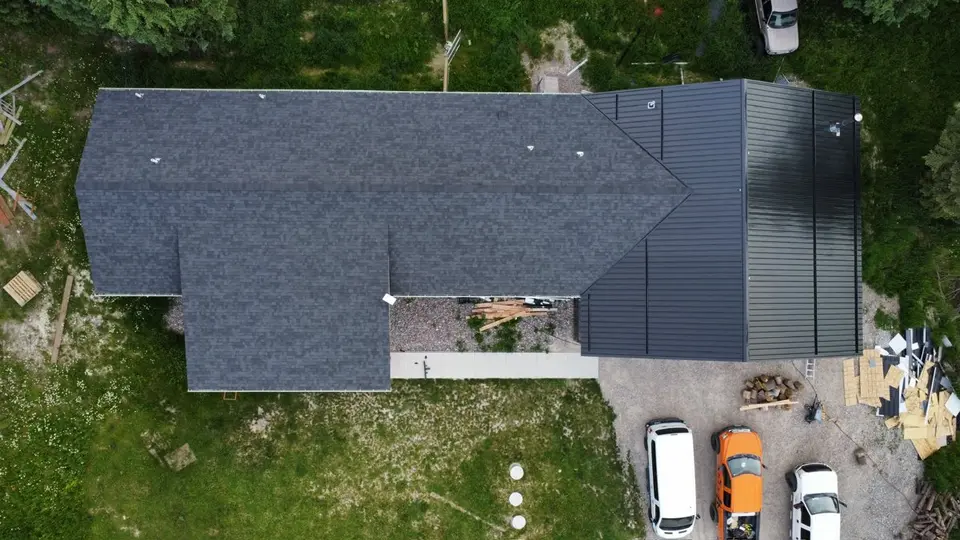 Drone aerial of a finished dark shingle roof on a mountain home