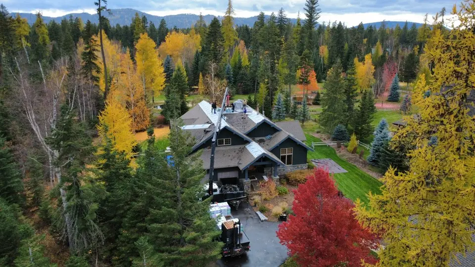 Drone view of a home with a complex multi-gable shingle roofline