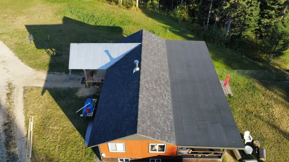 Drone aerial along the ridge of a completed shingle roof in northwest Montana