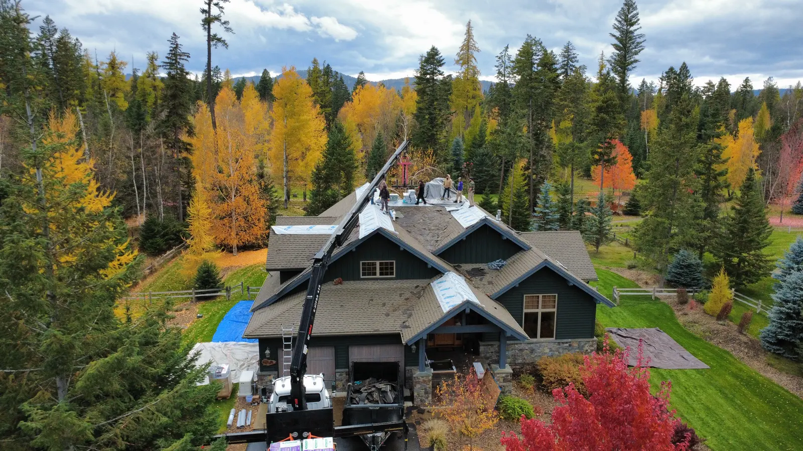 Drone aerial of a Sisu crew reroofing a craftsman home near Kalispell in fall